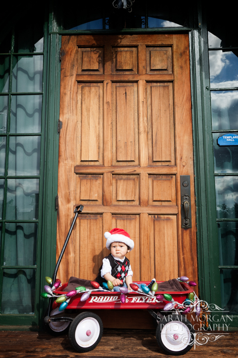 Sweet little baby boy in Radio Flyer wagon all ready for Christmas