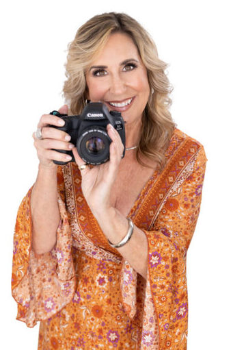Photo of Sarah Morgan in orange dress with camera