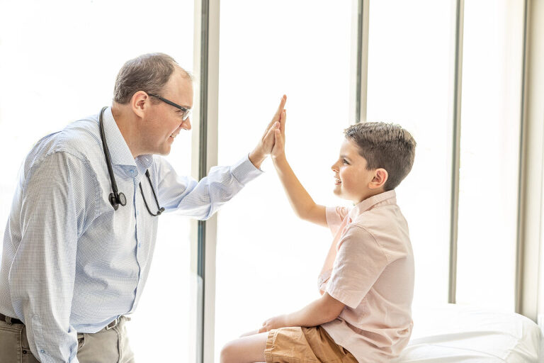 Brand image for Health Matters Direct Primary Care. Image showing doctor high-fiving with a young patient